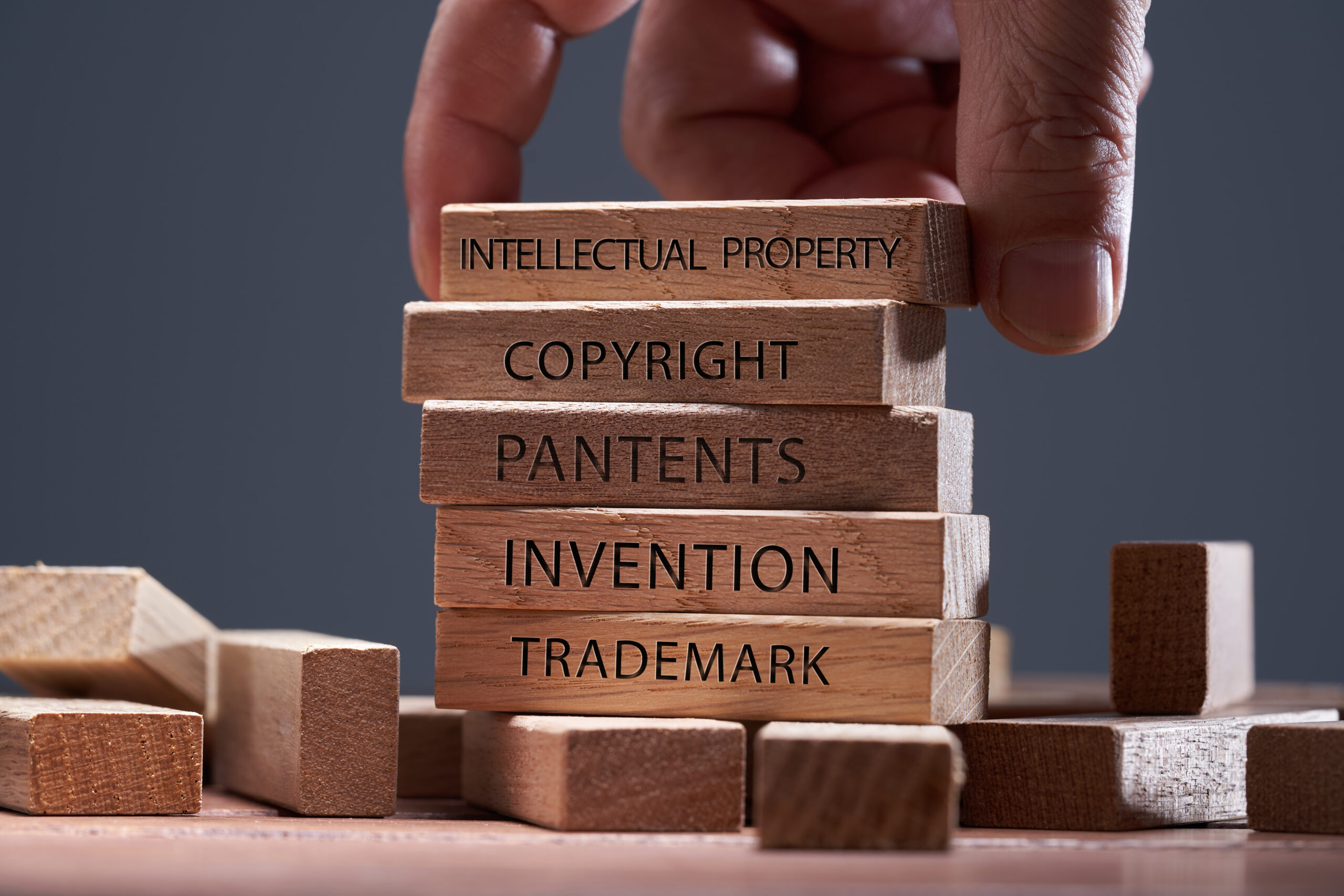 man adding a  block showing the words ’Intellectual property